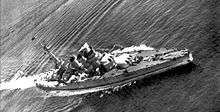 A low quality photograph of the battleship in the open seas, taken from above