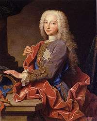 A nine-year-old boy wears a powdered per-wig, striking a typical Baroque pose.