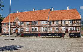 Half-timbered brick building with tiled roof