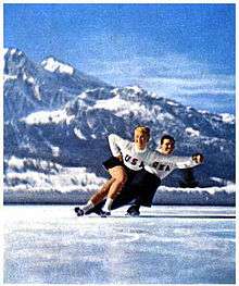 A man and woman in figure skating attire skating on ice.