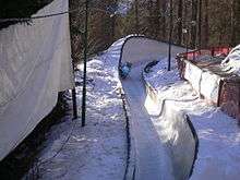 A blue sleigh in a turn of a bobsleigh run