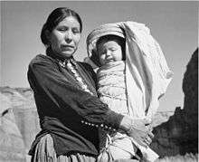 Black and white photograph of a Native American woman holding a child
