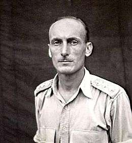 Head-and-shoulders portrait of man with thin moustache and high forehead, wearing light-coloured military shirt