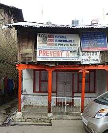 A run down a two-story building with a number of signs related to AIDS prevention
