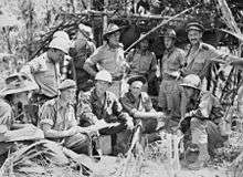 Australian and US soldiers planning operations amidst a jungle setting