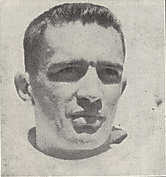 Black and white neck-up photograph of Akins in a football uniform