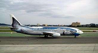 Right side view of an aircraft taxiing on the ground with a giant salmon painted on the fuselage.