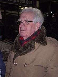 A man wearing a grey coat and scarf.