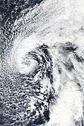 A non-tropical cyclone with clouds wrapping cyclonically around an open center; a distinct front can be seen to the southeast of the storm