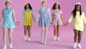 Five women dancing in front of pastel-colored pink backdrop.