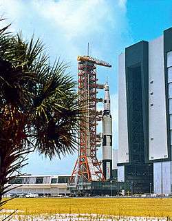 Photograph of the Saturn V Launch Vehicle on display, lying on its side outdoors and separated into segments.