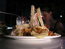 A club sandwich and potato chips on a plate at the Sci-Fi Dine-In