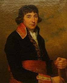 Painting of a man with long dark hair over his ears. He wears a dark blue French military uniform of the 1790s with a red sash around his waist.