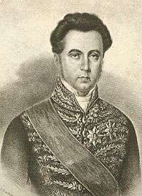 Lithographic half-length portrait of a man with dark hair and wearing a sash of office and medals over an intricately embroidered tunic coat