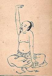 Old ink oriental drawing of a man performing qigong, kneeling cross-legged with an arm extended in the air