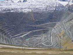 Photograph of the Bingham Canyon Mine, taken from near the rim looking down to the bottom of the mine pit. Alpine snows cover about the upper one-third of the terraces inside the mine.