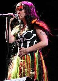 Colorful singer with long, dark hair onstage