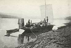 Prospectors sailing toward Dawson in boat on upper Yukon River, 1898