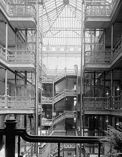 HABS interior photograph of the central court of the Bradbury Building, emphasizing the ornamental ironwork on the stairways and open walkways and the large skylight.
