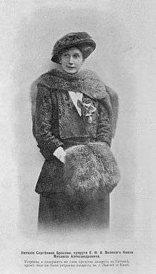 Three-quarter length portrait photograph of Natalia wearing an Edwardian-style dress and hat with furs