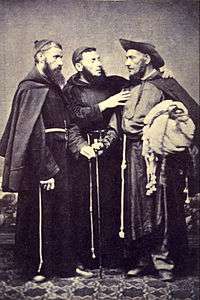 A photograph showing 3 standing men wearing religious habits