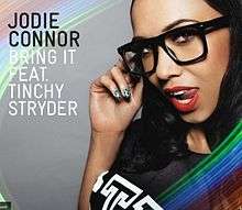 A portrait circled in a rainbow-like colour of a woman seductively posing with her right hand on her large black spectacles. She is wearing bright red lipstick and her tongue is positioned outside the left side of her mouth. To the woman's right in black stands 'JODIE CONNOR' and in white 'BRING IT FEAT. TINCHY STRYDER'.