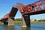 Red metal bridge with draw bridge section raised