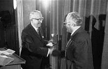 Walter Hallstein on stage, shaking hands while receiving prize