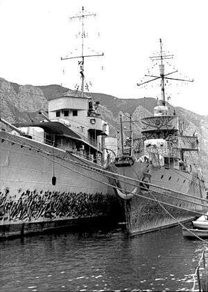 a black and white photograph of two ships at dock