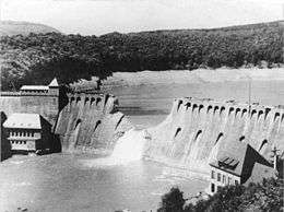 Dam with a V-shaped breach and water flooding through