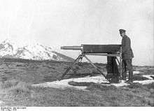 Soldier standing next to a Telescopic instrument on a tripod.