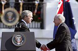Photograph of U.S. President George W. Bush shaking hands with Australian Prime Minister John Howard, during the State Arrival Ceremony held for the Prime Minister on the South Lawn of the White House, May, 2006
