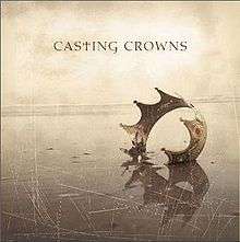 On a tan, scratched screen, a single crown lies embedded in the ground. Above it are the words 'Casting Crowns', with the lowercase 't' replaced with a Christian cross.
