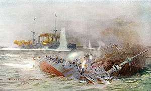 A large warship on its side in the water, exposing the red bottom; another large warship is seen in the distance afire and shooting its guns