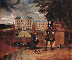Charles accepts a pineapple from a kneeling man in front of a grand country house