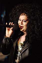 drag queen singing in to a microphone