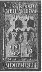 Two highly simplified female figures standing side by side, with snout-like faces, conical exposed breasts, extremely narrow waists and very wide hips. The figures each only have one arm, and appear to be joined at the shoulder. Crown-like points rise from their heads. Next to each figure is a branch. The words "Eliza & Mary Chulkhurst" are written above the figures, and the word "Biddenden" is written below them. The left figure has "In 1100" written on her dress, and the right figure has "A 34" written on her dress.