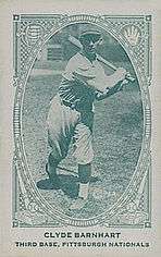 A man in a lightly colored baseball uniform swinging a bat.
