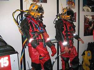 Two display dummies dressed in surface supplied diving equipment at a dive trade show
