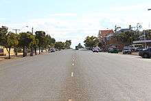 Photo of wide single carriageway road in a town