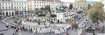 Small photo of people in folk costume in a city square