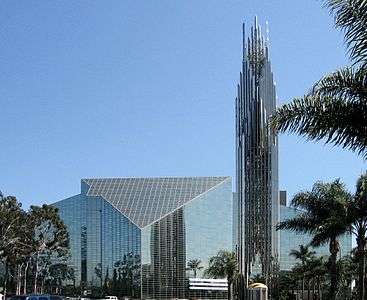The Crystal Cathedral is a built in a modern style with panels of glass set in metal frames making both the walls and roof. A tall tower of the same materials rises beside it