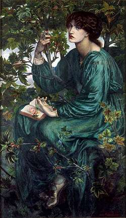 The dark haired model is dressed in green and seated in a sycamore tree