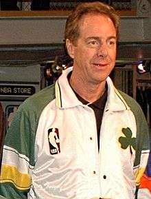 Portrait photograph of white man wearing white and green top