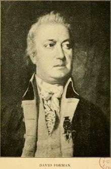 Print shows a man wearing a dark military coat with light colored turnbacks.