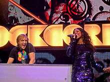 A picture of a man and woman DJing and singing