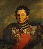 Painting of a smiling clean-shaven man with long sideburns. He wears a red military uniform with a fur-lined cloak thrown over his shoulders.