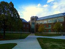 Picture of a three story building with walkways on an autumn day