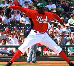 Dontrelle Willis pitching for the Cincinnati Reds. Willis is also wearing a green cap