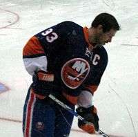 Doug Weight standing against the rink boards, wearing the captain's "C" on his jersey.